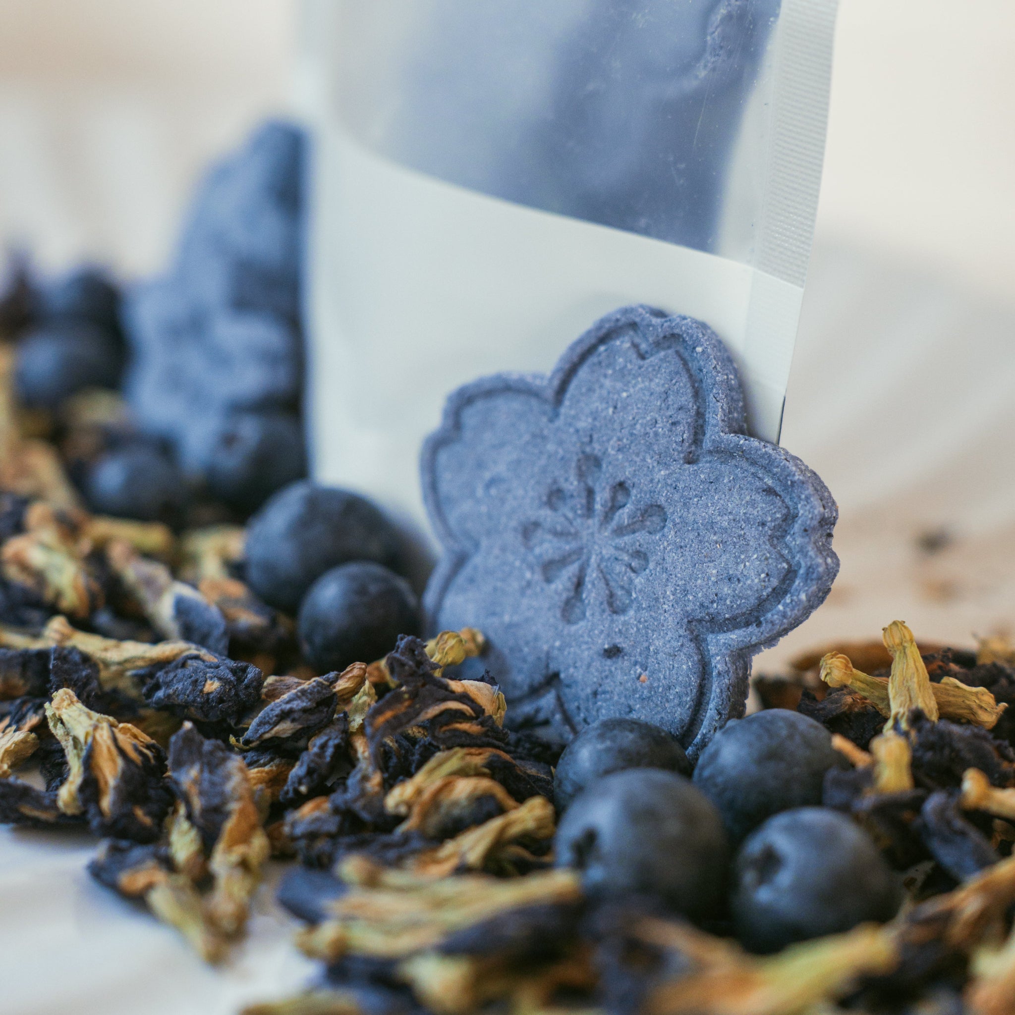 Blueberry Bliss dog treats packaging with blueberry-shaped biscuits and dried flowers styled on a plate