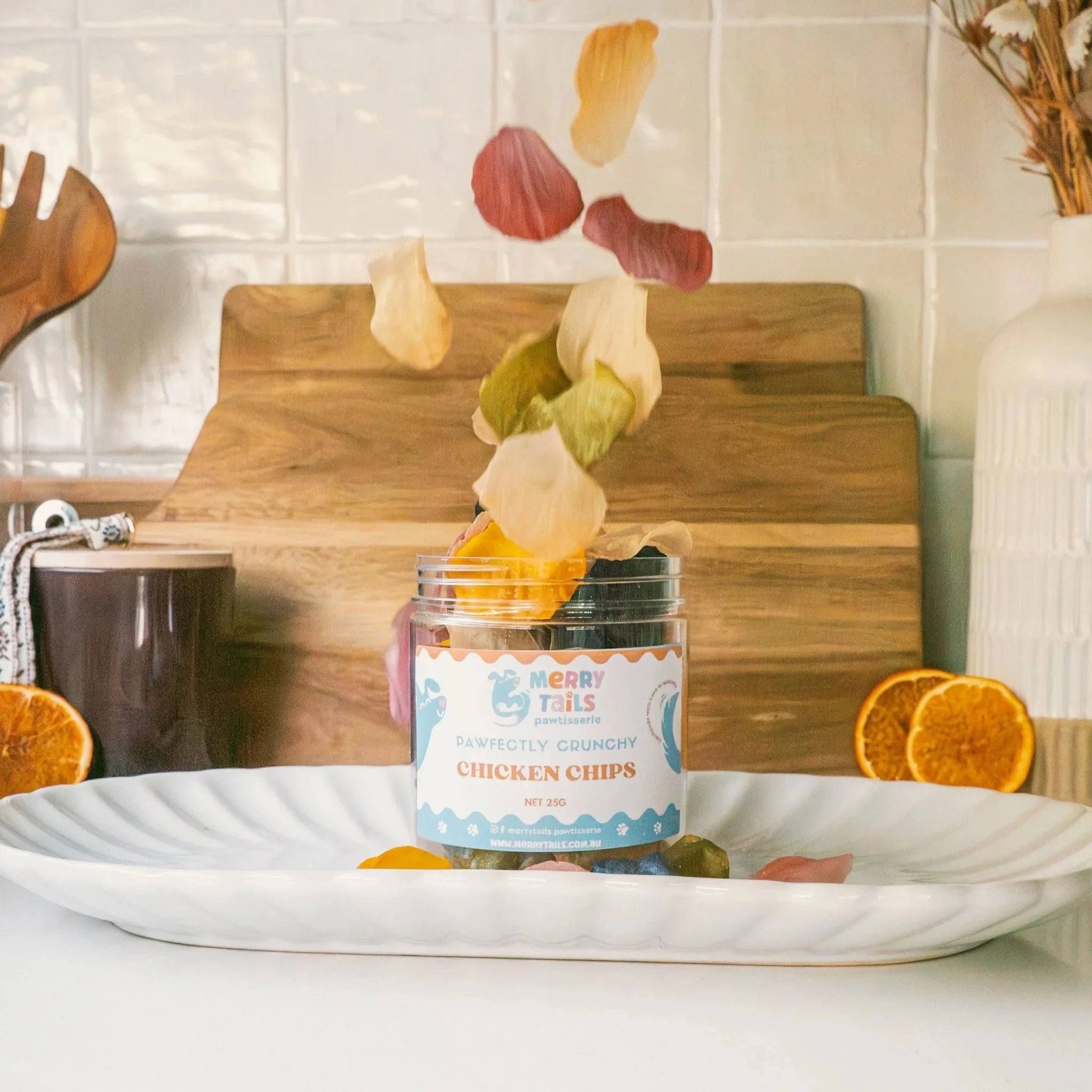 Crunchy chicken dog treats falling into a glass jar on a kitchen counter
