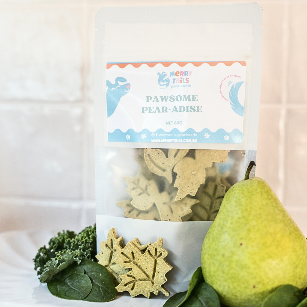 Pawsome Pear-adise dog treats by Merry Tails Pawtisserie with fresh pear and leafy greens in its packaging
